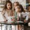 Girls blowing candles from birthday cake on table