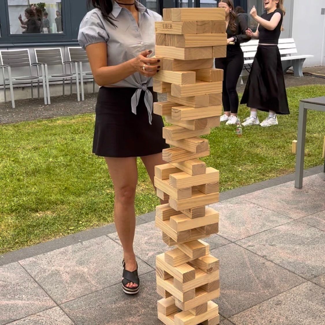 Outdoor party guests playing Giant Jenga rental game
