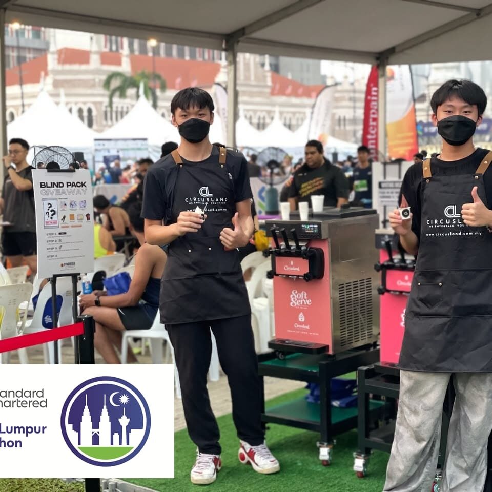 Circusland crews serving soft serve ice cream at the Counterpain booth during Standard Chartered Kuala Lumpur Marathon 2026 at Dataran Merdeka.